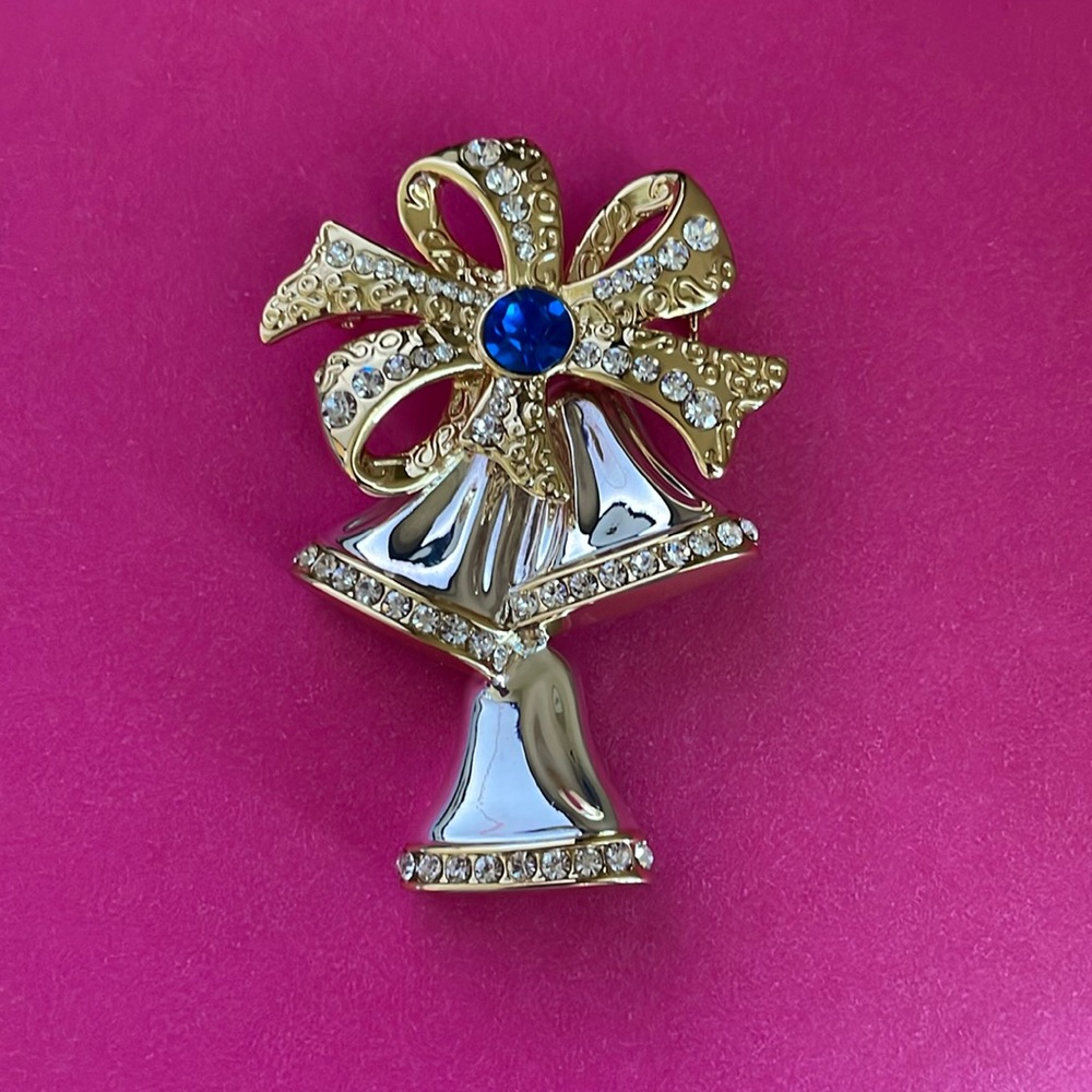 Gold bell and bow brooch with blue stone and clear stones‎